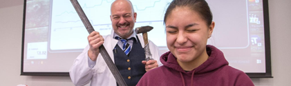 Student being demonstrated the effects of a piece of metal being hammered